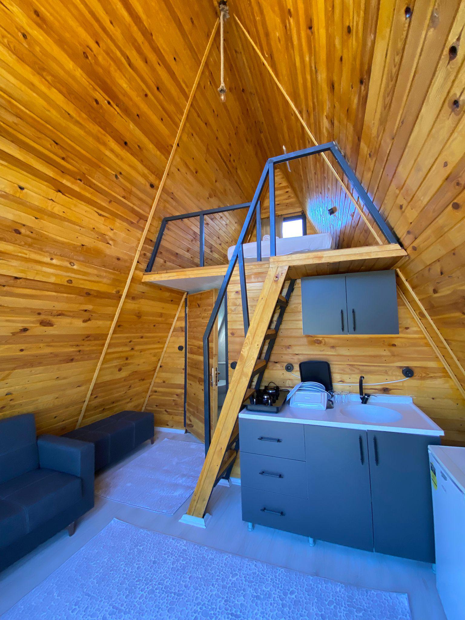 Doğa ile uyumlu bungalov dış cephesi, toprak ve kahverengi tonlarında, doğal çevre ve yeşilliklerle çevrili