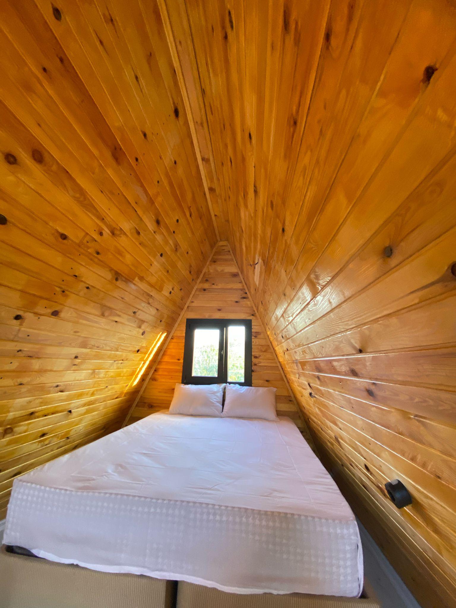 Ahşap malzemeden yapılmış modern bungalov dış cephesi, doğal toprak ve kahverengi tonlarında, yeşilliklerle çevrili