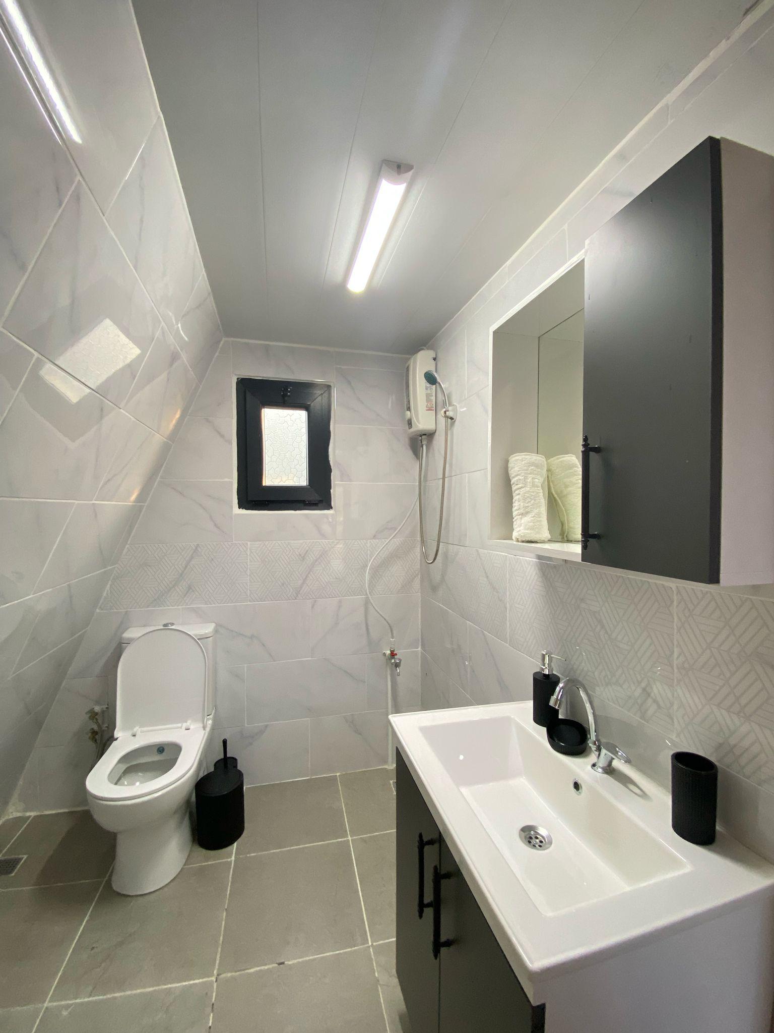 Göl kenarında modern bungalovlar, yumuşak sabah ışığı ve hafif sis, toprak ve soft yeşil tonlar